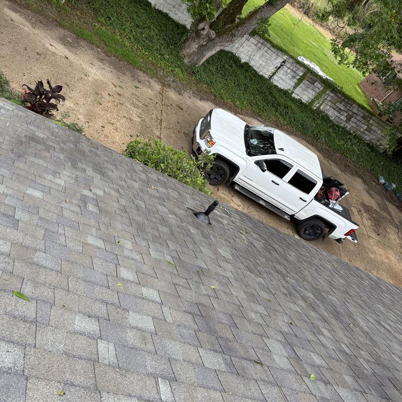 Pipe boot on shingle roof with white truck below