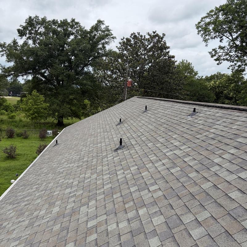 Roof pipe boots with installed vent caps on shingle roof