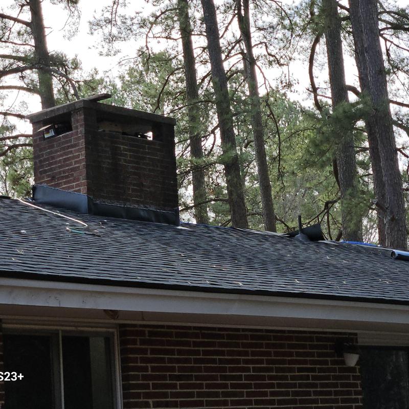 Roof shingles and brick chimney on residential roof Roof shingles and brick chimney on residential roof