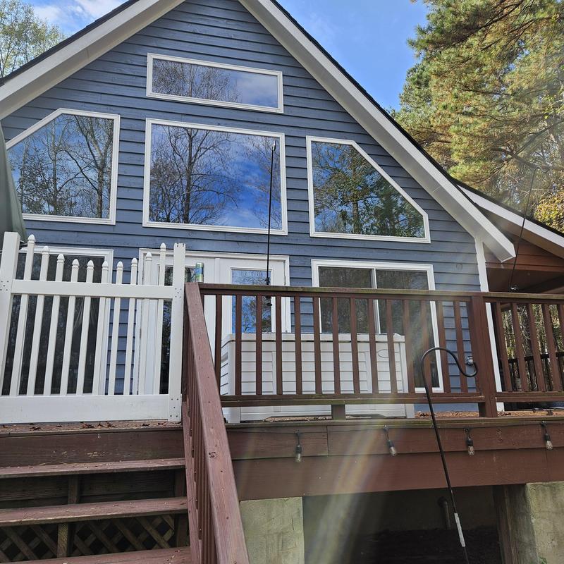 Wooden deck railing and stairs on blue house exterior Wooden deck railing and stairs on blue house exterior
