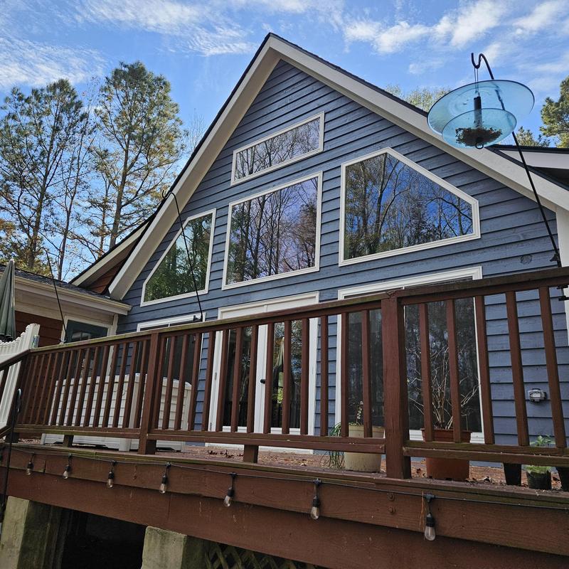 Deck railing and wood deck installation on blue house Deck railing and wood deck installation on blue house