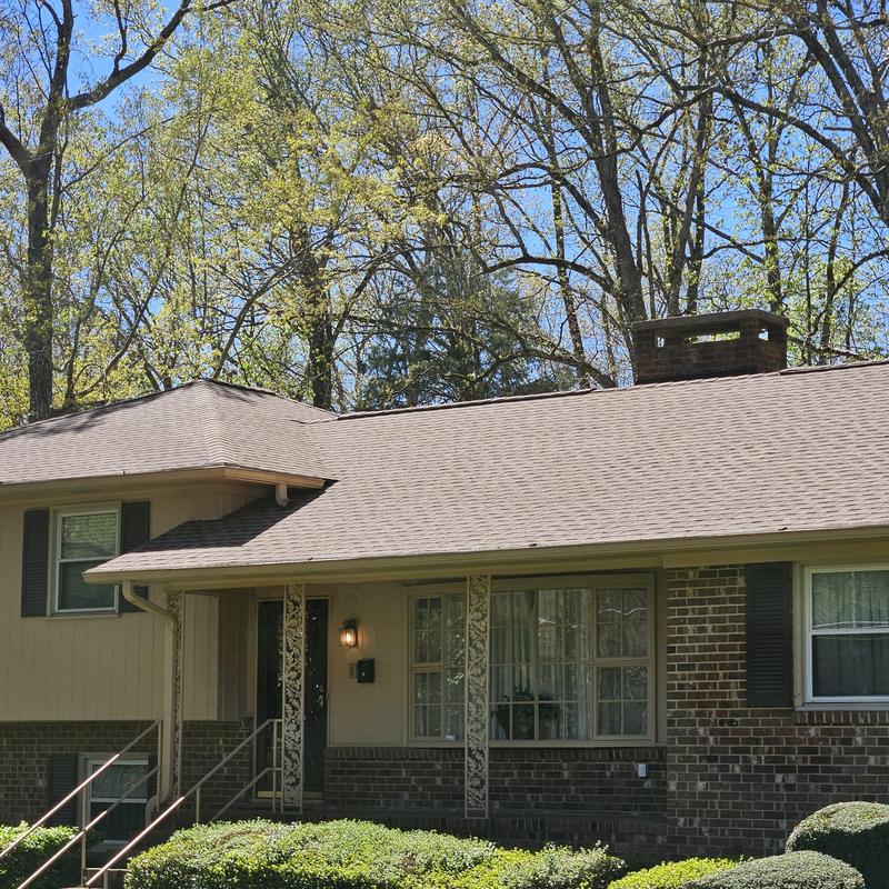 Roof shingles on residential house under spring trees Roof shingles on residential house under spring trees