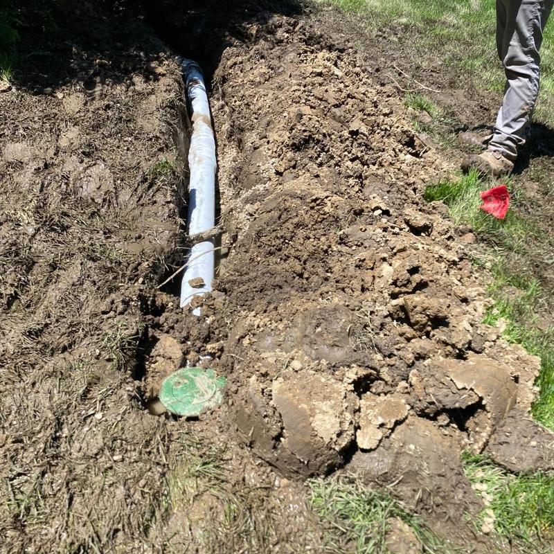 Sump pump discharge line installation in trench