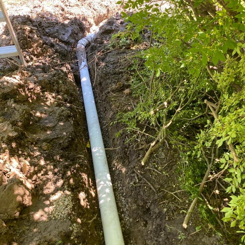 Sump pump discharge pipe installation in trench