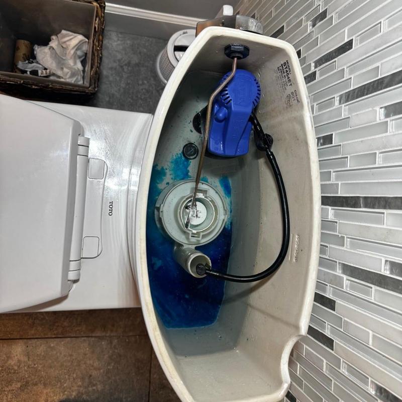 Toilet fill valve with blue dye in tank