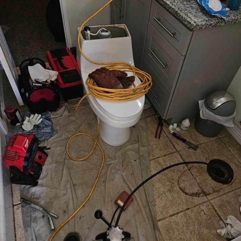 Toilet sewer line clog with drain cleaning machine