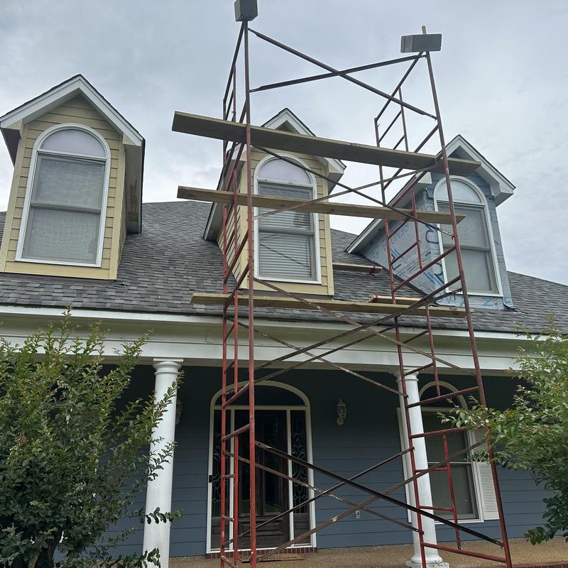 Dormer window scaffolding setup on house exterior