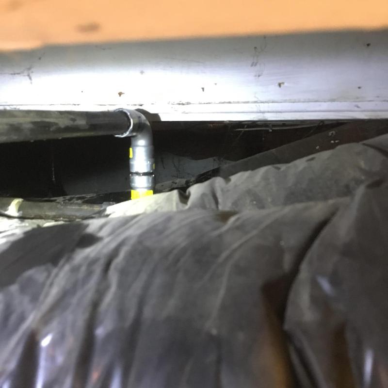 Natural gas line with elbow joint under floorboards