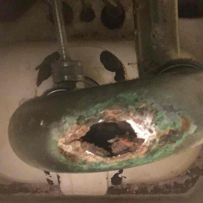 Corroded sink drain pipe with severe rust hole