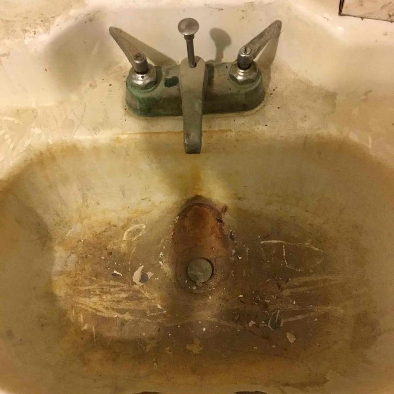 Bathroom sink with severe rust and corrosion damage