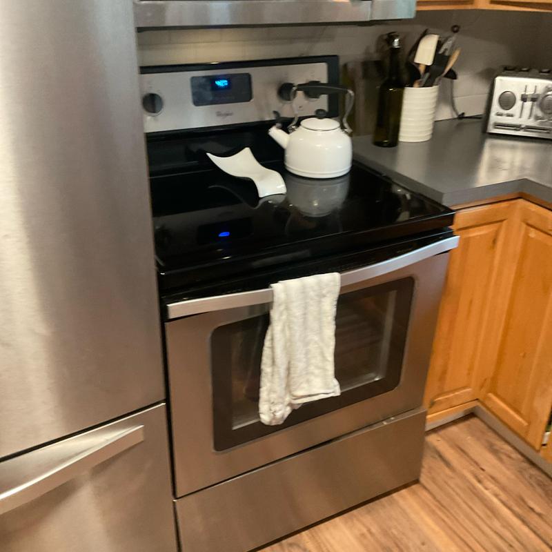 Electric stove with kettle and towel in kitchen