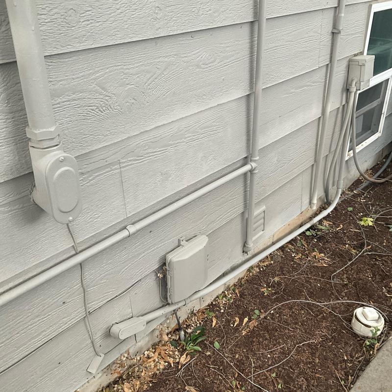 Gas line conduit and outdoor electrical connections on house exterior
