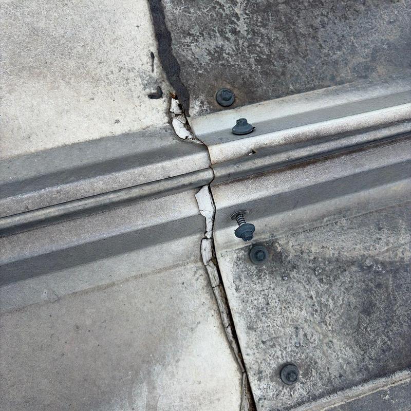 Standing seam metal roof panel splice with cracks