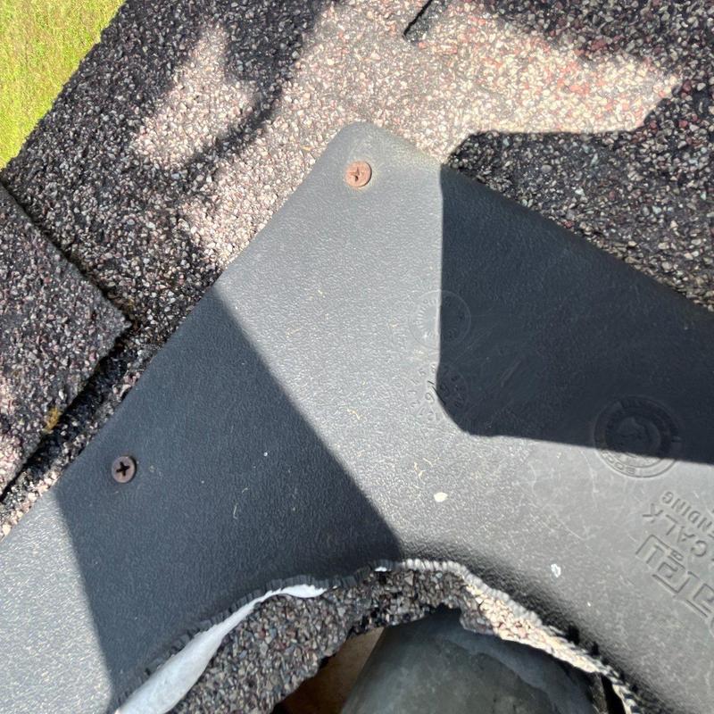 Dryer vent flashing with rusted screws and damaged shingles