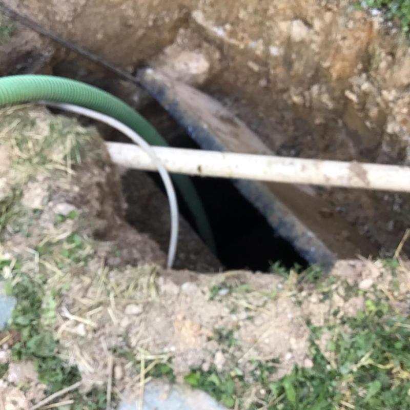 Septic tank opening with hoses for pumping in dirt