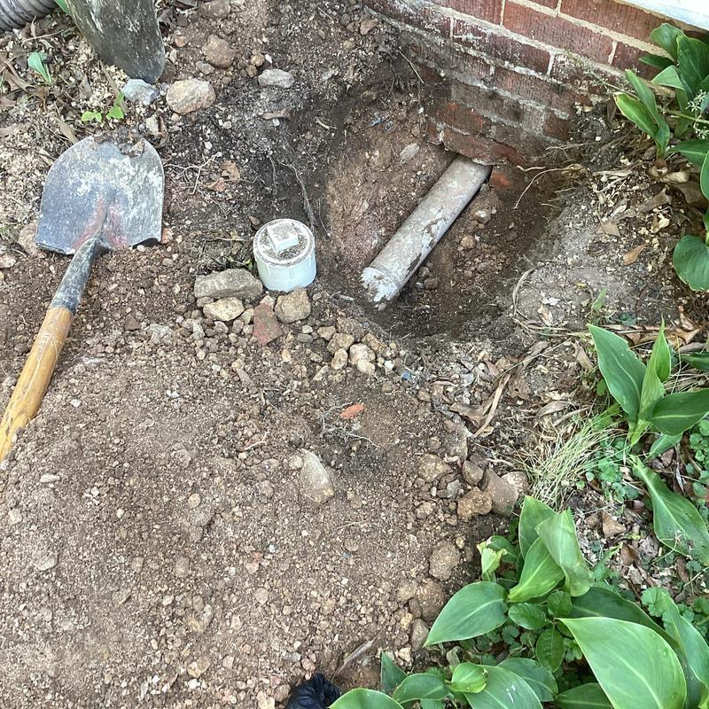 Septic tank line excavation near brick house wall