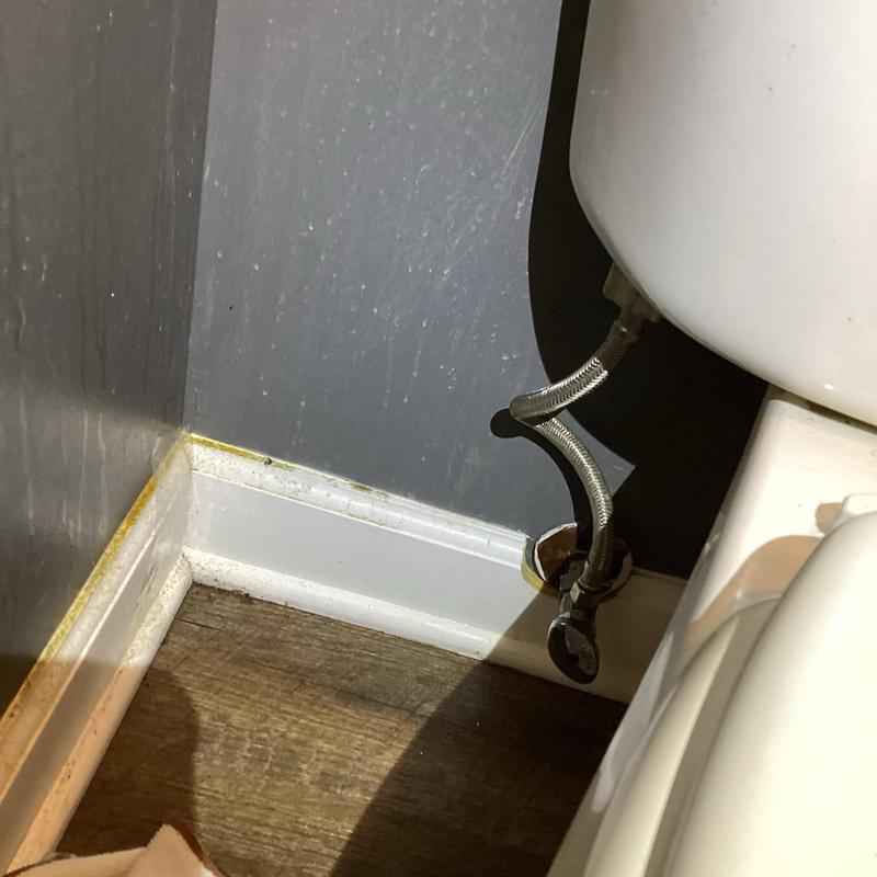 Toilet water supply line with shutoff valve near baseboard