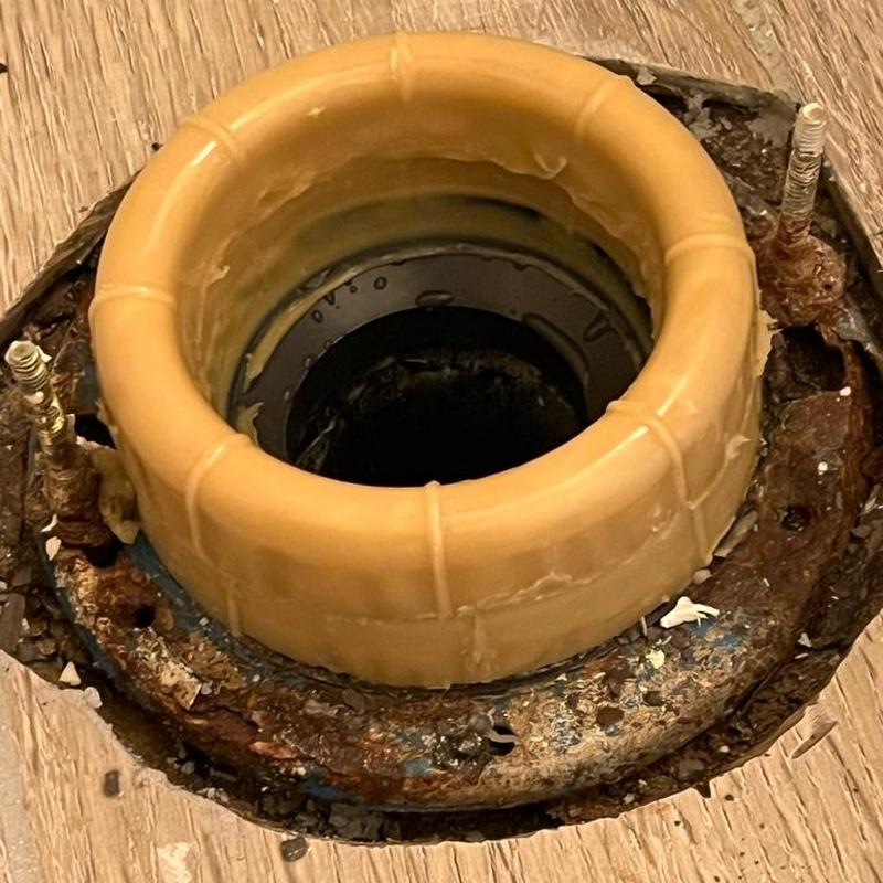 Toilet flange with rusted mounting bolts and wax ring seal Toilet flange with rusted mounting bolts and wax ring seal