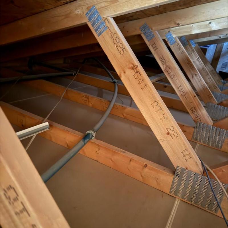 Main waterline pipe with new strap in attic above garage Main waterline pipe with new strap in attic above garage