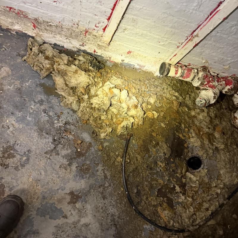 Indoor plumbing pipe with hardened debris buildup Indoor plumbing pipe with hardened debris buildup