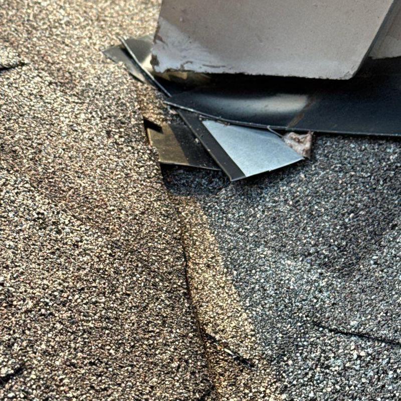 Roof shingles and flashing with hail damage near vent