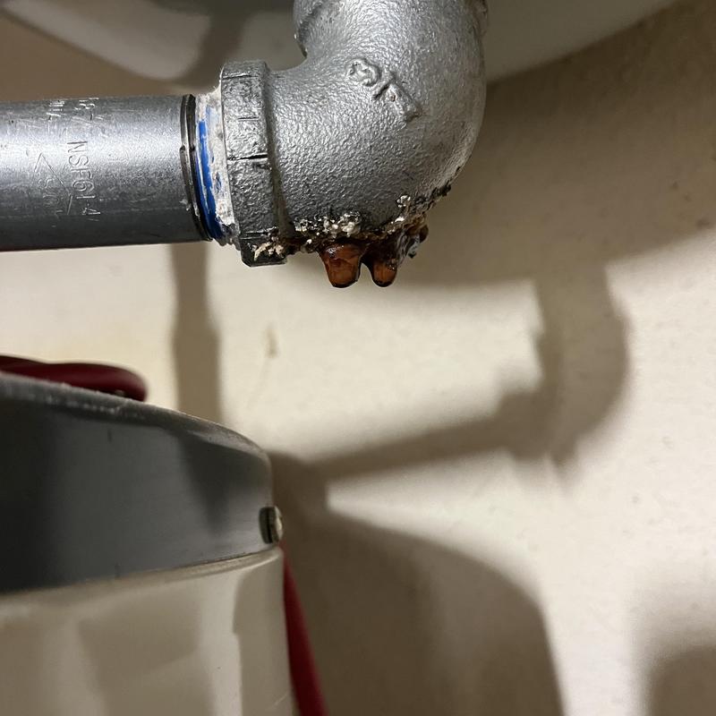 Water heater pipe leak with rusted corrosion visible