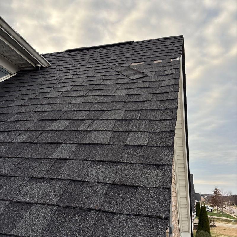 Asphalt shingles with hail damage and lifted ridge vents