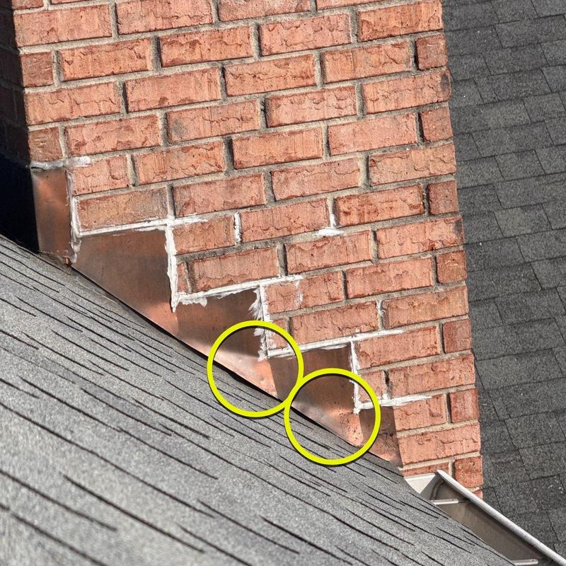 Roof flashing with hail damage near chimney