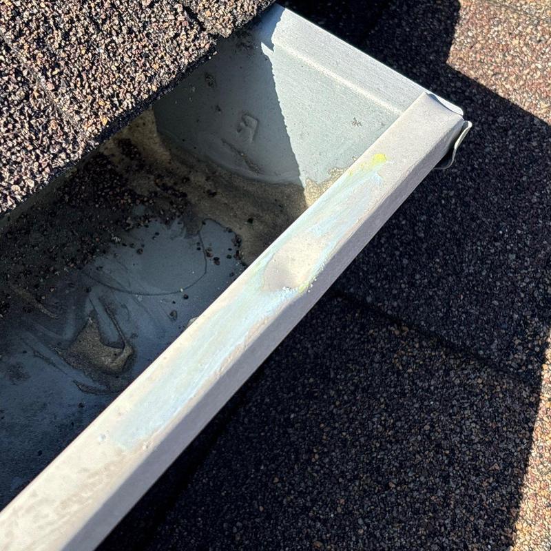 Gutter with hail dent near asphalt shingles