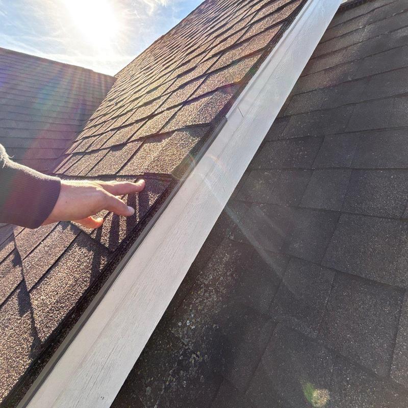Roof shingles with hail damage and finger pointing