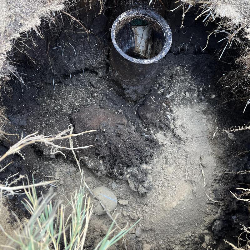 Septic tank outlet pipe excavation with soil layers