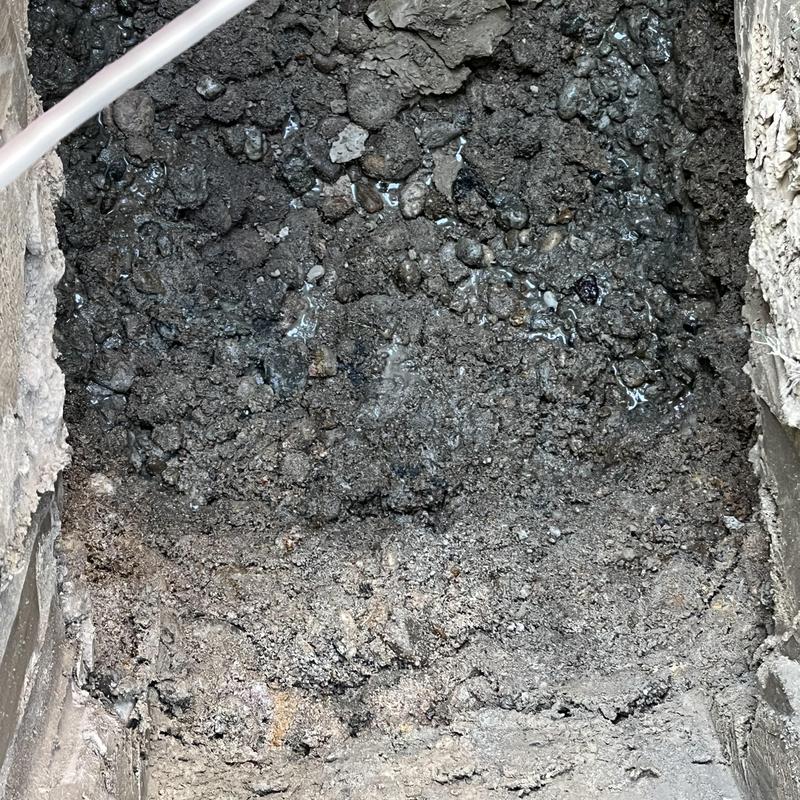 Septic tank outlet piping excavation showing saturated soil