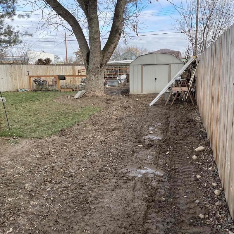 PVC piping trench alongside yard fence near shed