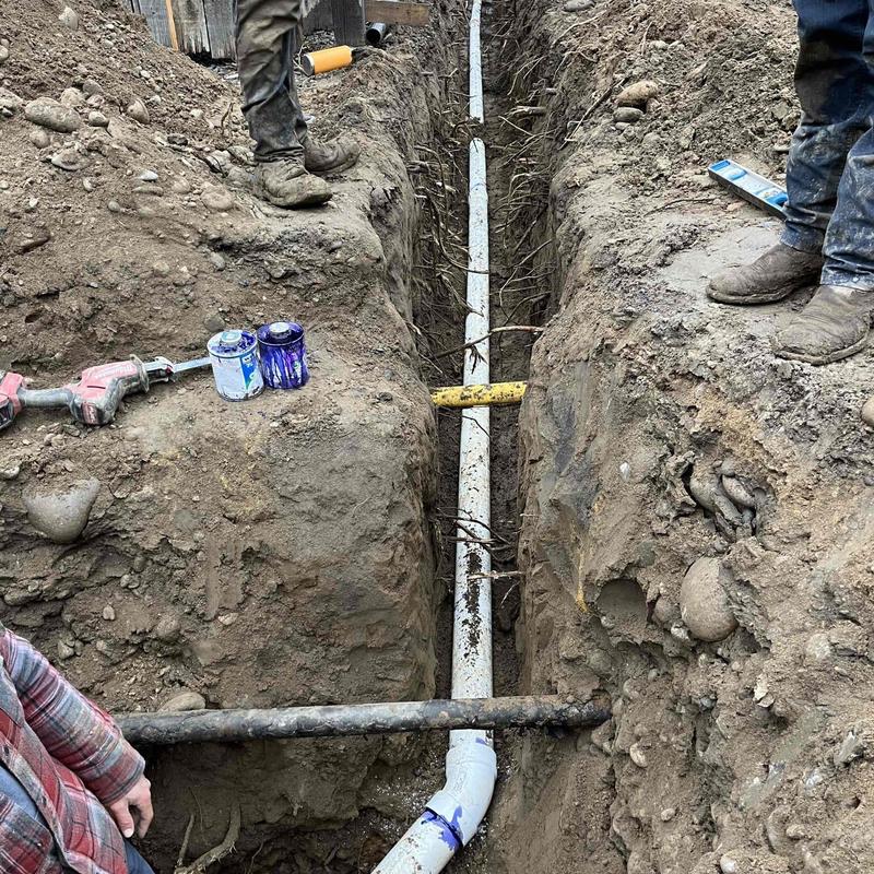 PVC piping installed in trench alongside driveway