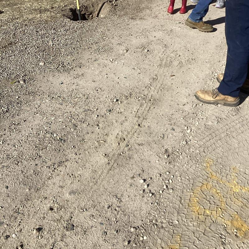 Sewer line excavation site with utility markings and boots