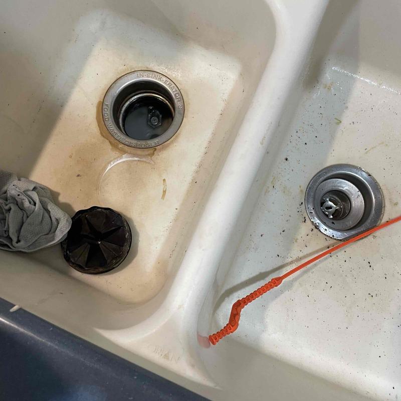 Kitchen sink drain with orange drain snake tool