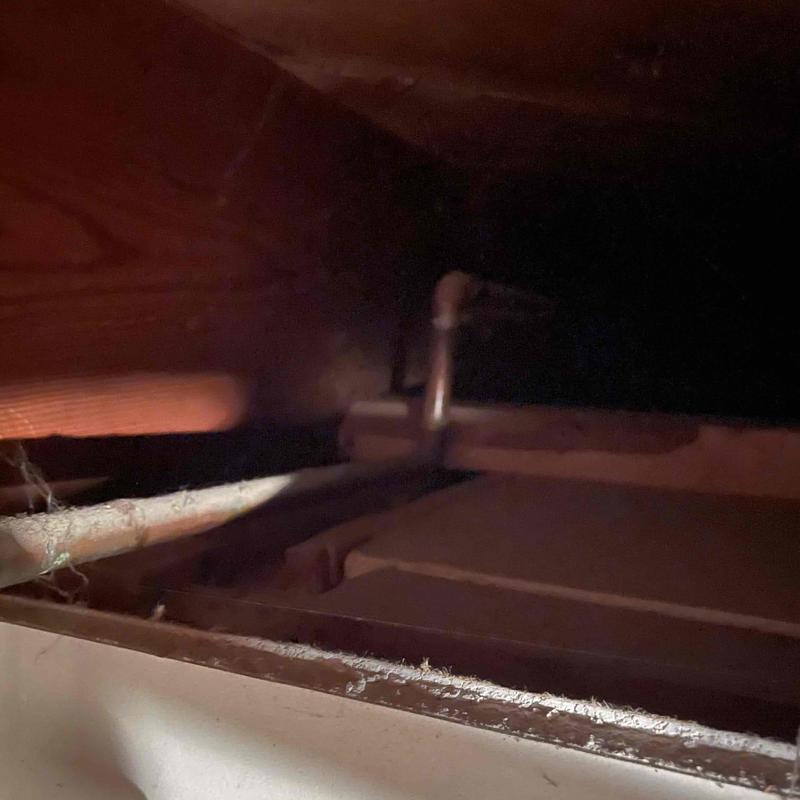 Copper drain pipe in dark crawl space area