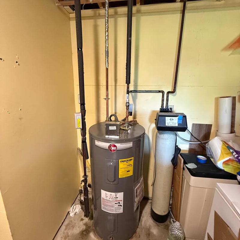 Rheem water heater with connected pipes in utility room