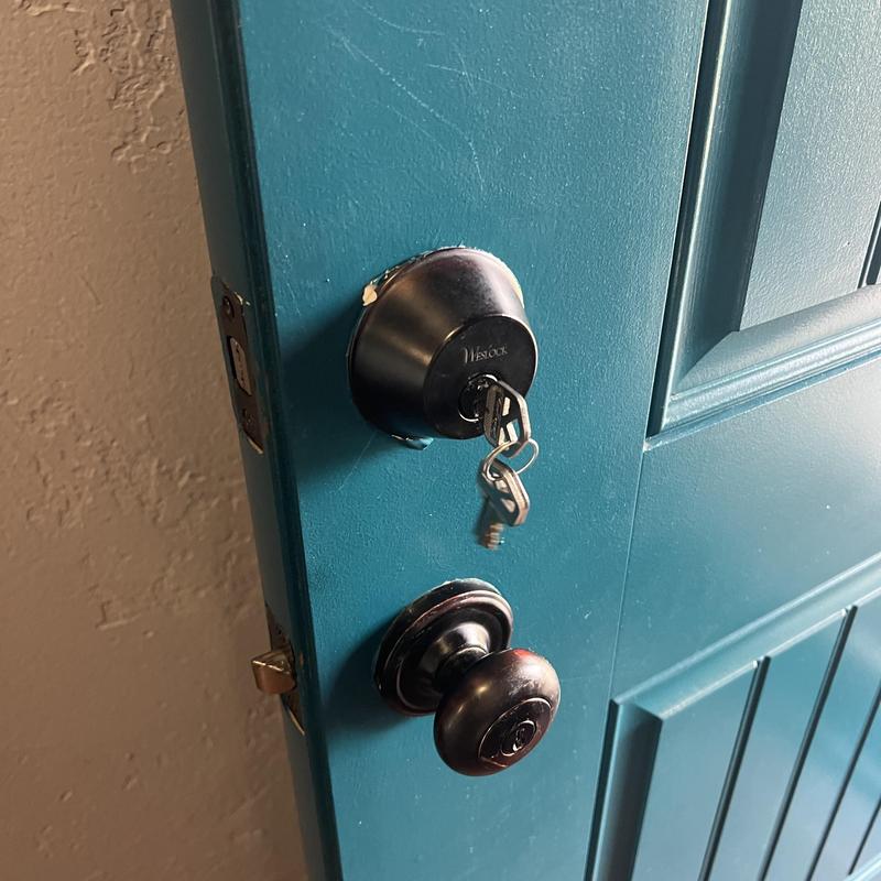 Deadbolt lock with keys on blue exterior door