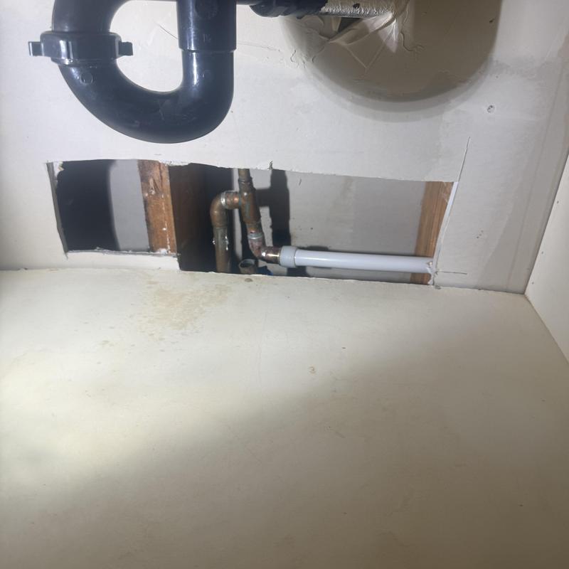 Copper water pipes with plastic pipe repair under vanity
