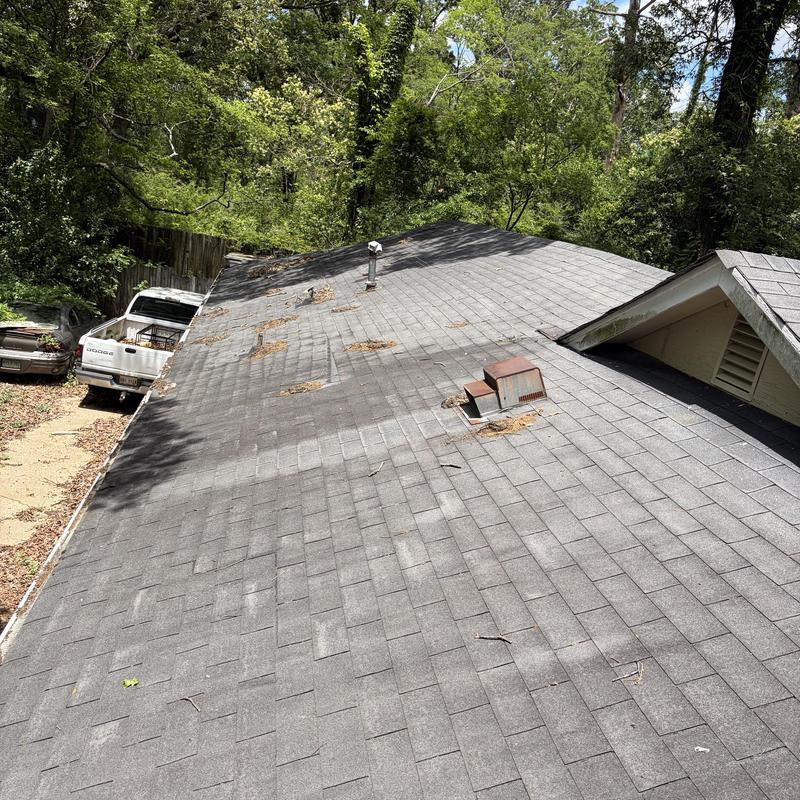 Asphalt shingle roof with debris and wear marks