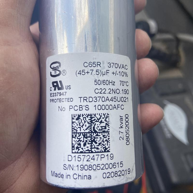 HVAC capacitor label close-up in hand