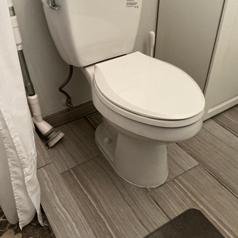 Bathroom toilet with flush tank on tile floor