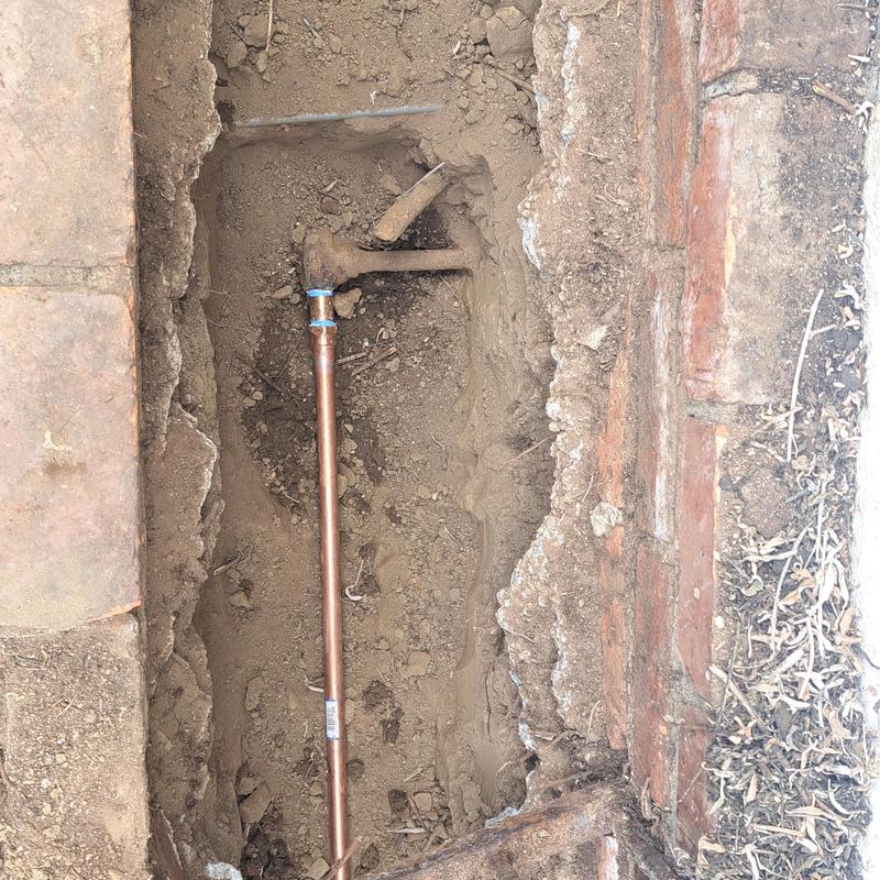 Copper water line exposed in backyard slab trench