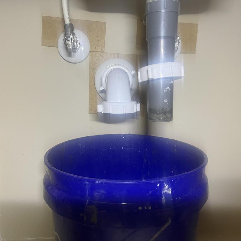 Sink drain pipes with blue bucket catching water Sink drain pipes with blue bucket catching water