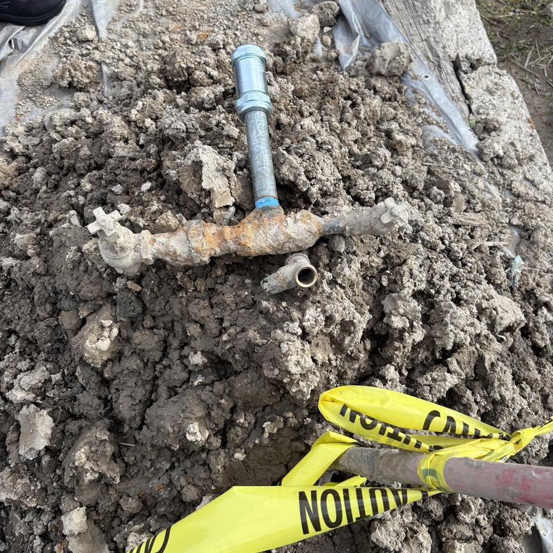 Waterline valve by meter with caution tape in dirt