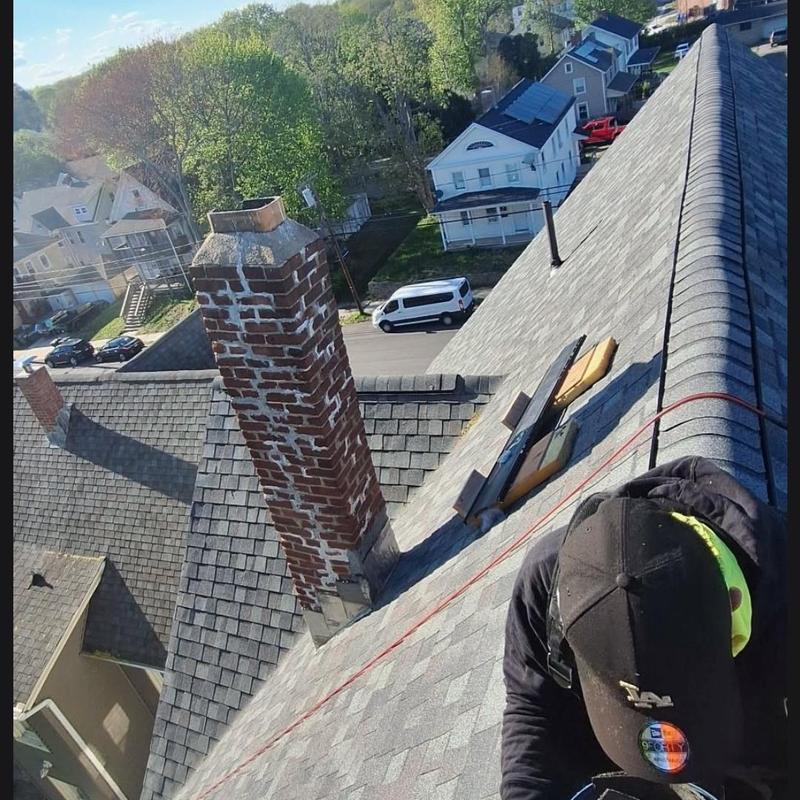 Asphalt shingle roof installation with brick chimney Asphalt shingle roof installation with brick chimney
