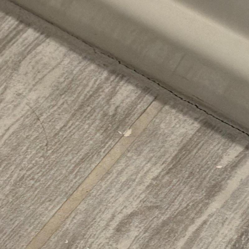 Tile grout with cracking near wall edge