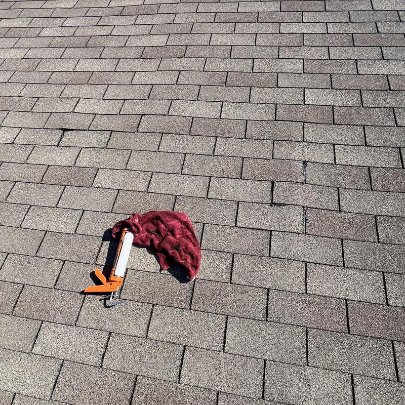 Asphalt shingle roof with sealant and cloth on surface