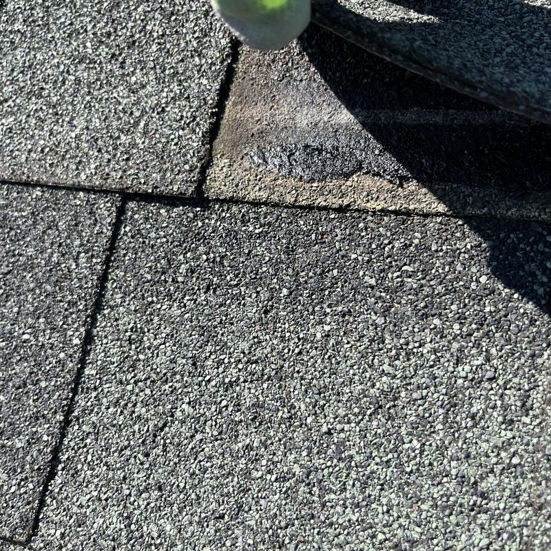 Asphalt shingles roof with damaged area under inspection